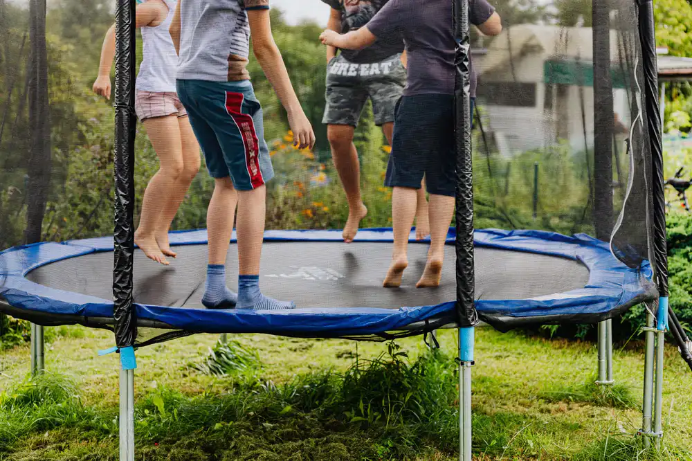A group of kids energetically jumping and celebrating at the indoor trampoline park